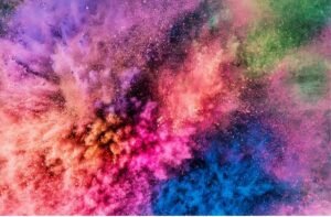 Pessoas lançando pó colorido durante o festival Holi, espalhando alegria e cores pelo ambiente