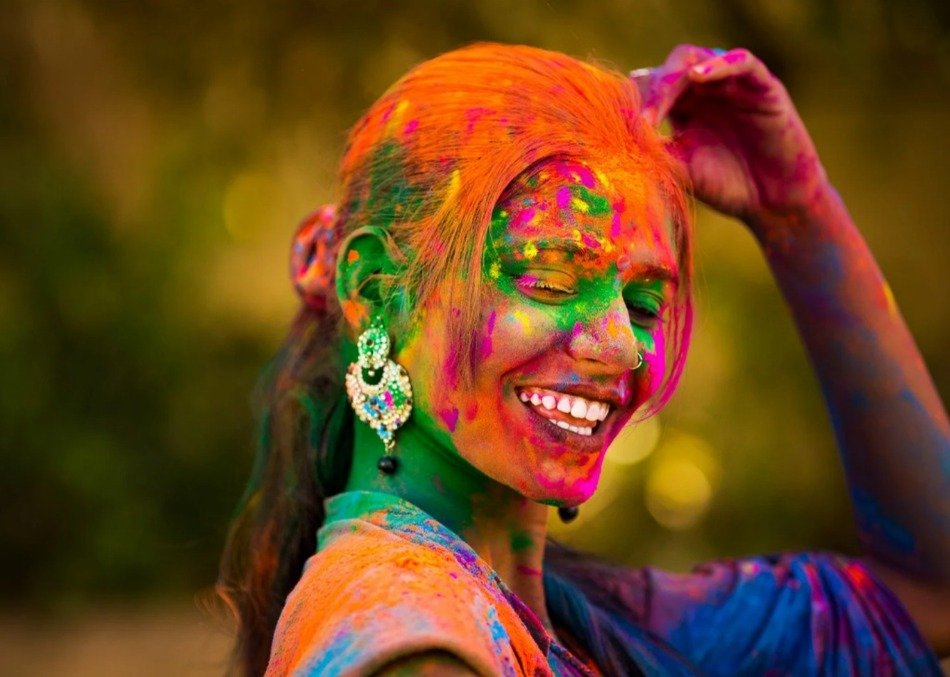 menina-brincando-holi Menina sorridente jogando pó colorido na festa de Holi