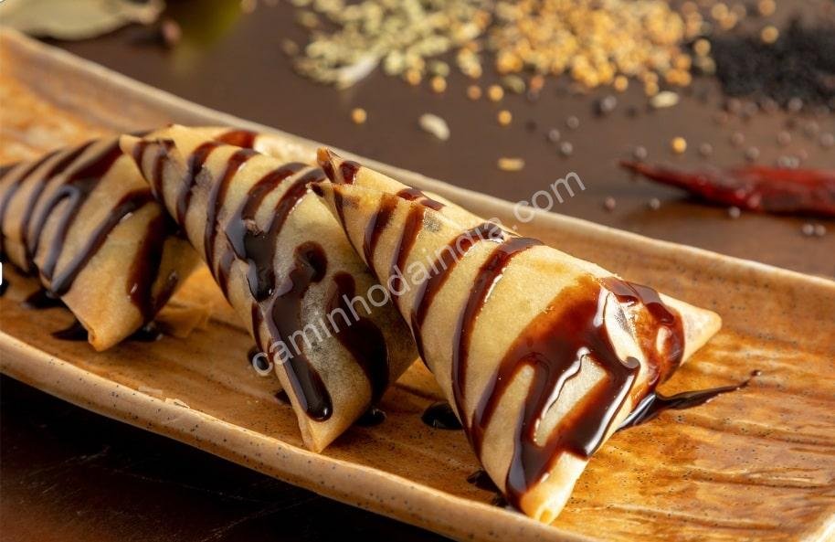 samosa-com-molho-de-chocolate-picante-min Samosa crocante servida com molho de chocolate picante