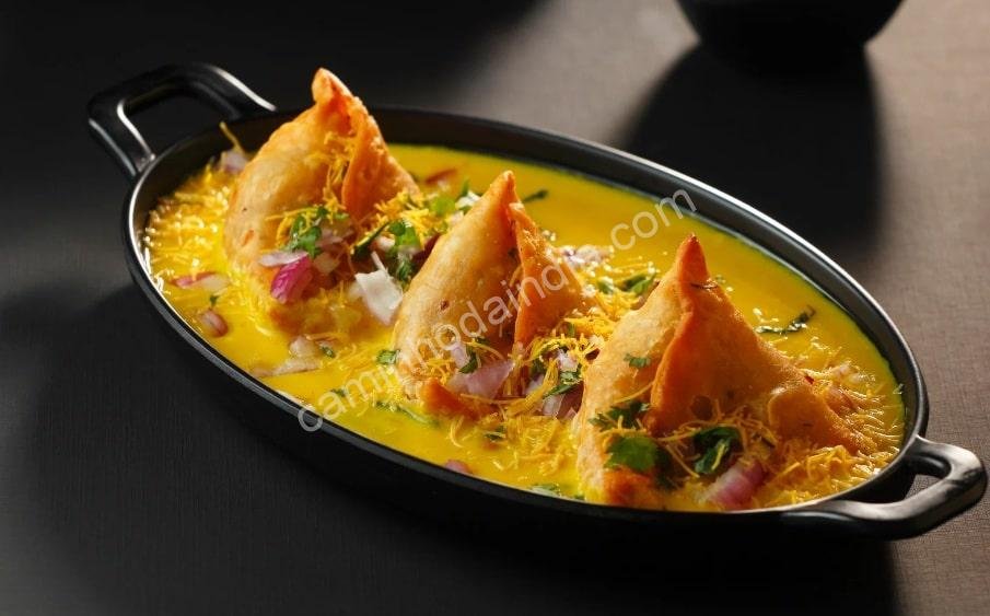 samosa-no-molho-curry-min Samosa mergulhada em um molho de curry cremoso e cheio de sabor, uma variação deliciosa da receita tradicional