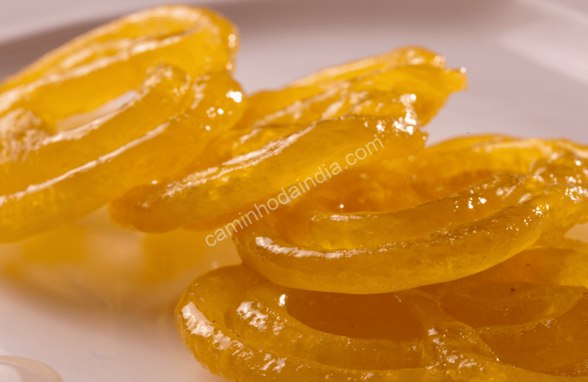 Textura detalhada do jalebi mostrando a absorção uniforme da calda de açúcar