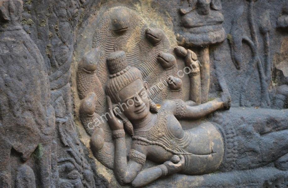 vishnu-deitado-shesh-naag-templo Detalhe de uma escultura antiga mostrando Vishnu repousando sob o capuz da serpente Shesh Naag, localizada em um templo histórico da Índia