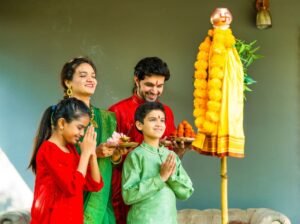Família indiana orando durante o festival Gudi Padwa, com decoração tradicional e guadi hasteada