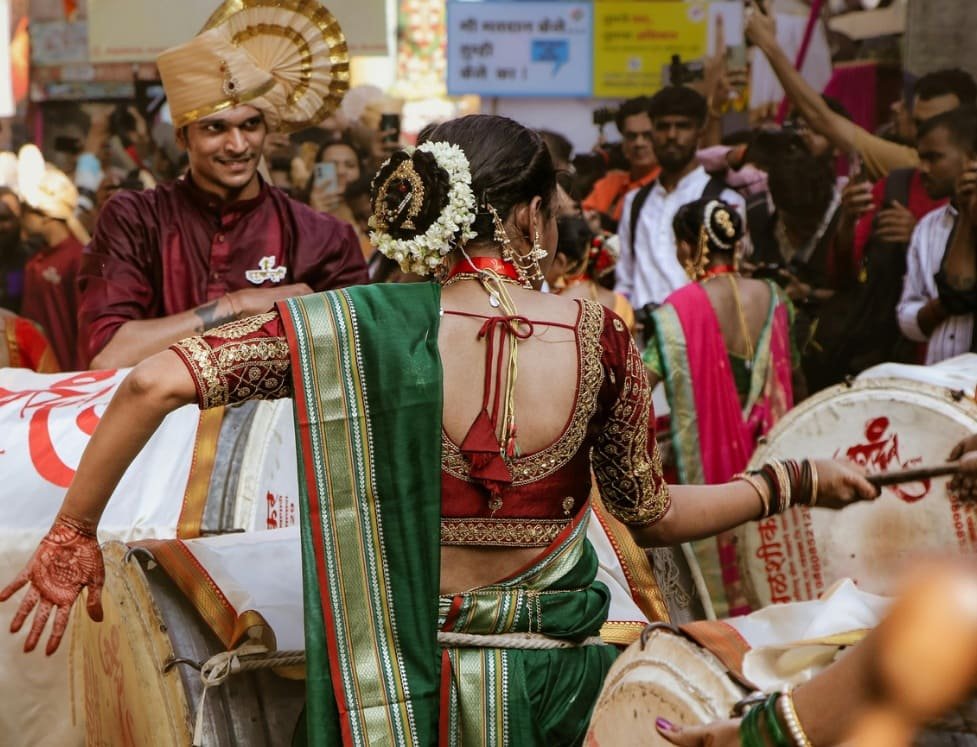 Mulheres tocando dhol durante a procissão de Gudi Padwa, vestidas com roupas tradicionais e vibrantes