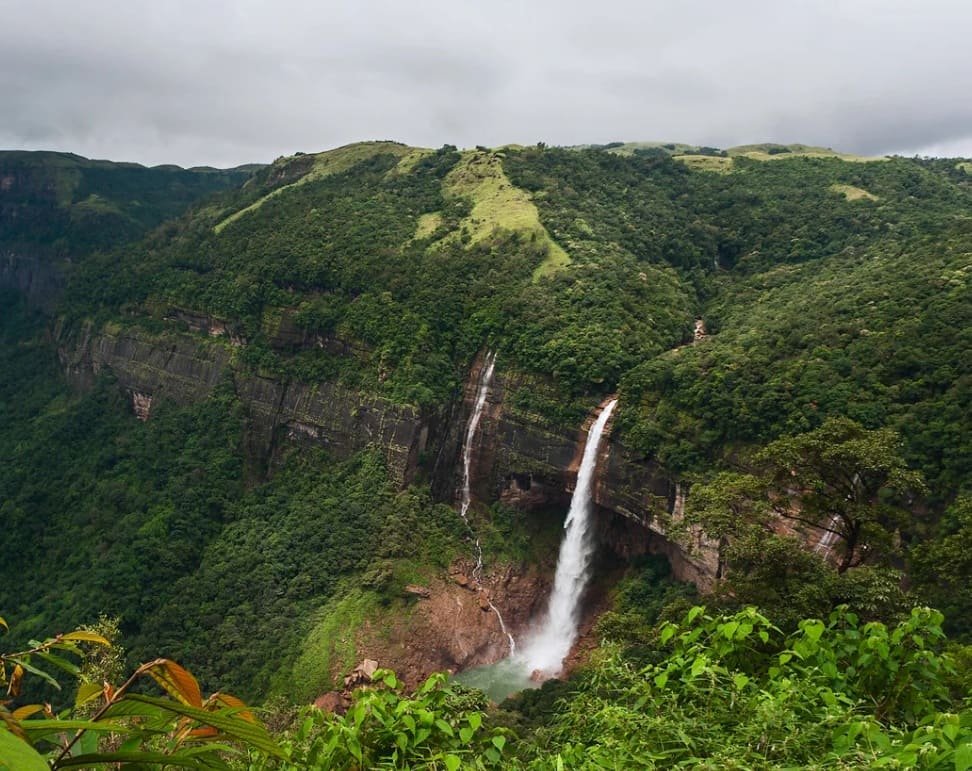 Cachoeira exuberante nos Ghats Ocidentais da Índia durante a temporada de chuvas, com vegetação verde intensa
