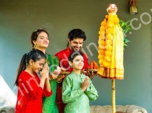 Família indiana orando durante o festival Gudi Padwa, com decoração tradicional e guadi hasteada