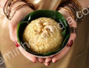 Mulher indiana vestida com traje tradicional oferecendo pratos típicos durante o festival Pongal