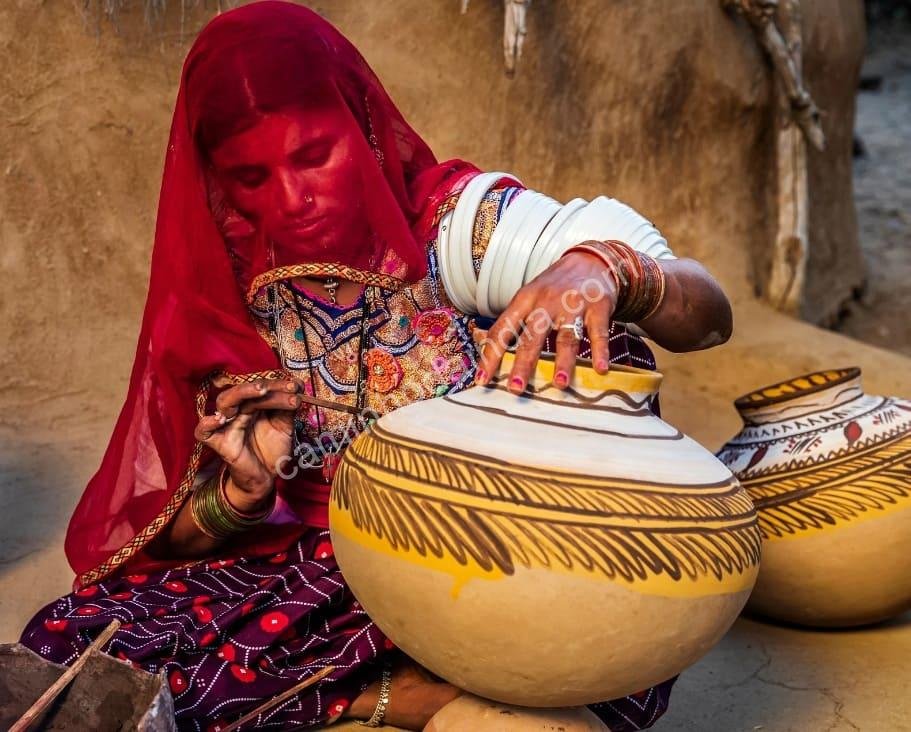 Uma mulher de Rajasthan dedica-se à arte tradicional de pintar potes de barro, símbolo da rica herança artesanal do estado