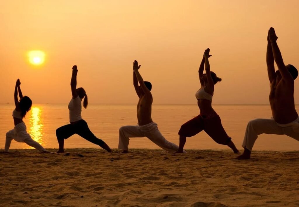 pessoas-praticando-yoga-na-praia Pessoas praticando yoga na praia, conectando corpo e mente em meio à natureza e à tranquilidade do mar