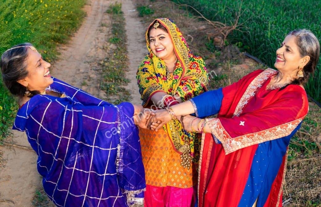 Mulheres punjabi dançando em meio a um campo agrícola, representando a alegria e as tradições rurais do Punjab