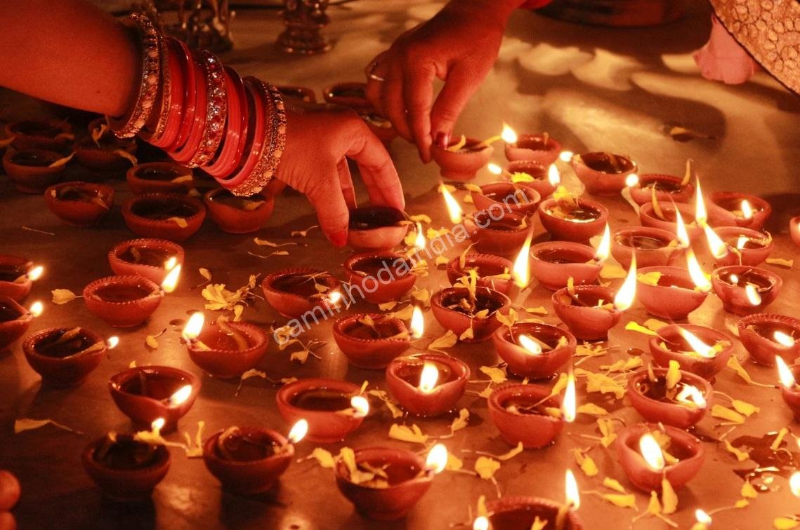 pessoas-colocando-diyas-govardhan-puja-diwali Pessoas arrumando diyas em frente às suas casas durante o Govardhan Puja no período de Diwali