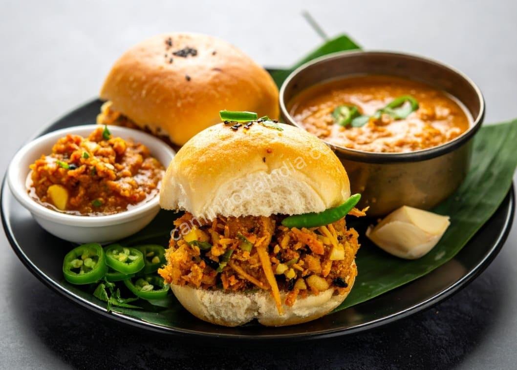 Vada pav gourmet servido em restaurante, acompanhado de chutneys, cebola e pimentas — uma versão moderna do lanche de rua mais amado de Mumbai