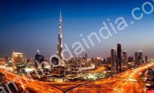 Vista noturna de Dubai com arranha-céus iluminados e reflexos brilhando sobre a água